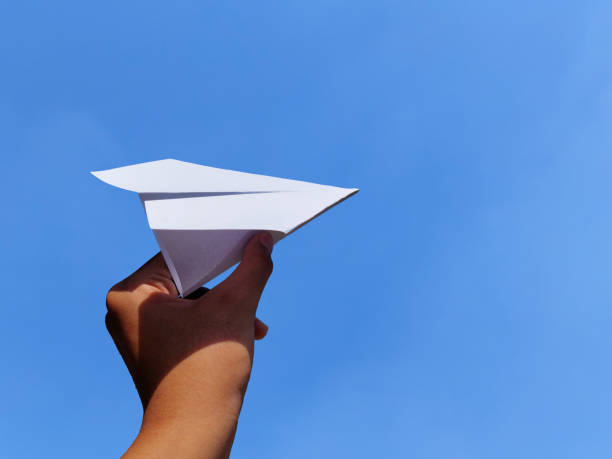 istock Hand holding paper airplane on blue sky background 1407650632