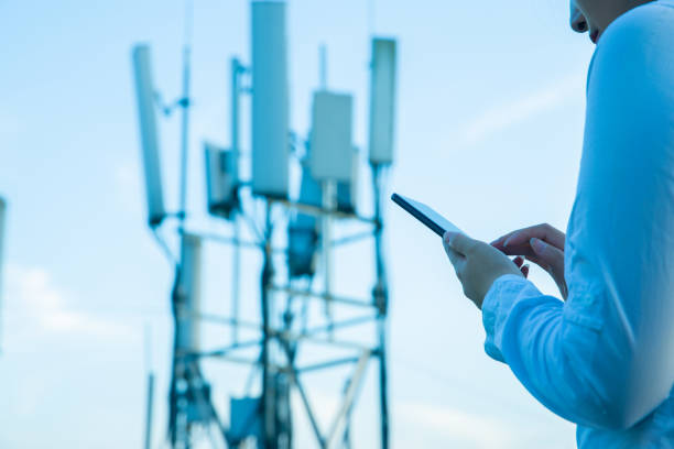 istock Human hand using mobile phone near 4G,5G communications tower 1407650638
