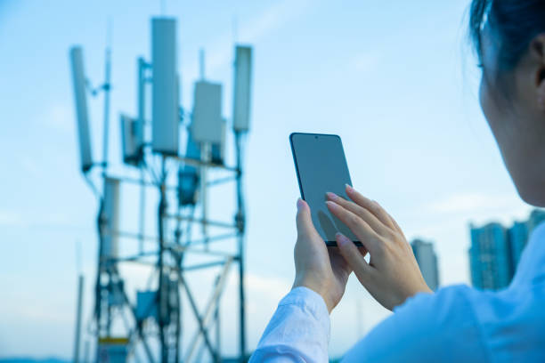 istock Human hand using mobile phone near 4G,5G communications tower 1407650651