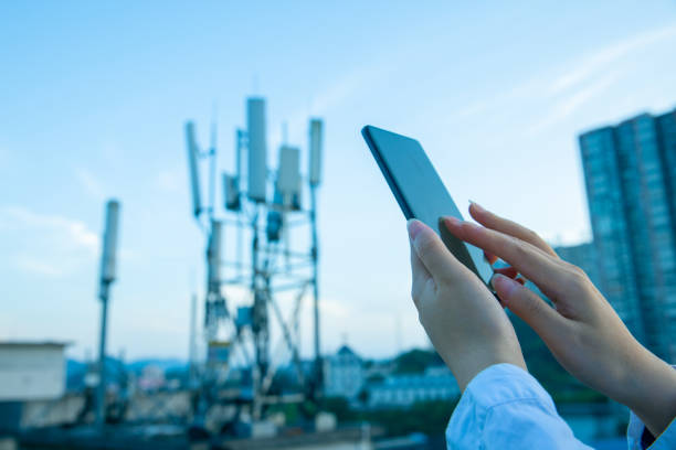 istock Human hand using mobile phone near 4G,5G communications tower 1407650687
