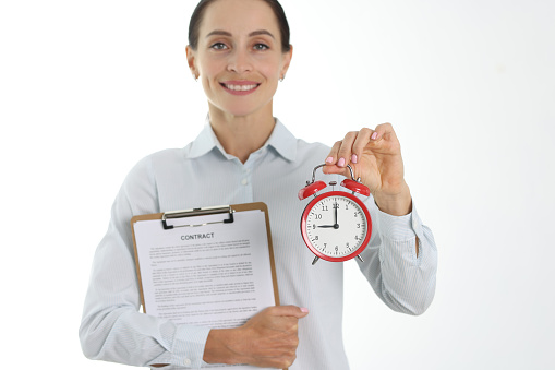 Businesswoman holding contract and alarm clock. Time to conclude business contract concept