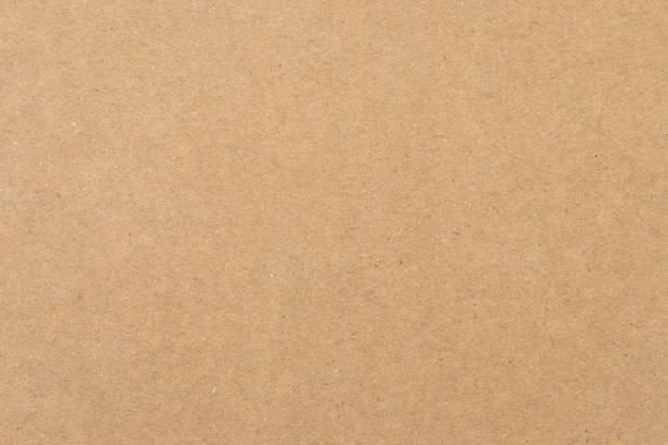 Texture of old paper, brown background. Yellow packaging, vintage dirty page. Craft sheet, natural pattern of papyrus. Carton container surface close up. stock photo