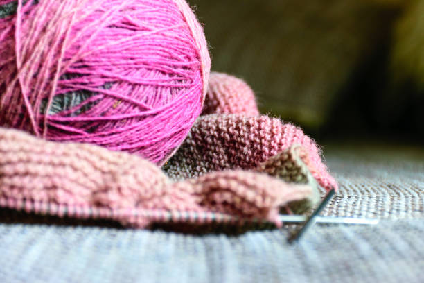 istock variegated color balls on the knitted textile background, wool yarn and knitting tools - knitting in progress 1407654079