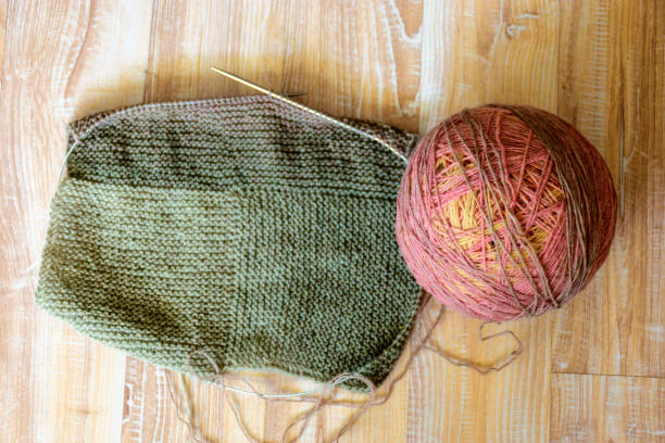 istock variegated color balls on the knitted textile background, wool yarn and knitting tools - knitting in progress 1407657503