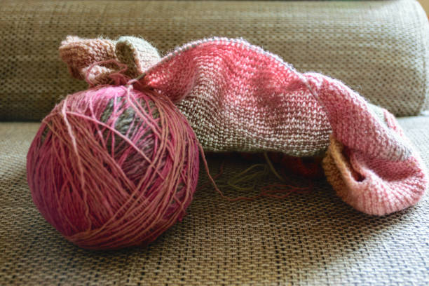 istock variegated color balls on the knitted textile background, wool yarn and knitting tools - knitting in progress 1407657651