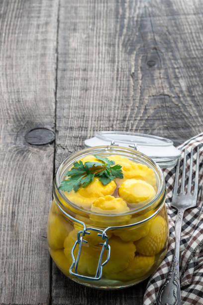 istock Marinated yellow squash in glass jar on wooden table 1407658503