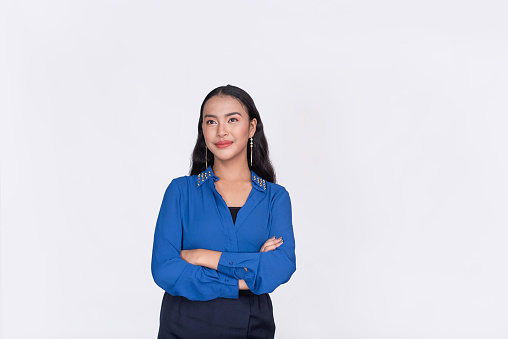 An optimistic female office intern with arms crossed. Isolated on a white backdrop.