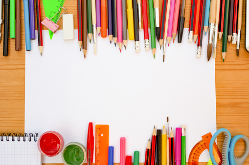Colorful school supplies on wood table.