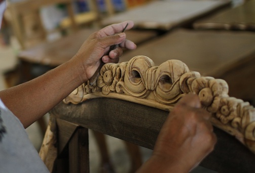 Man, people, job, young student at work learning craftsman profession in art class, working with wooden statue and carving wood