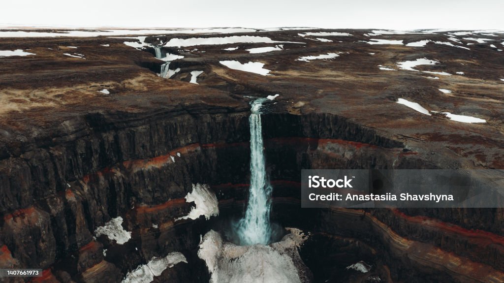 Scenic aerial view of the hidden huge waterfall in the colorful canyon in Iceland Drone panoramic photo of the beautiful tall Hengifoss waterfall hidden in the layered canyon at East Iceland Aerial View Stock Photo