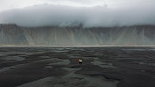 Aerial view of man and woman walking at the scenic Stokksnes beach with sand dunes in Iceland