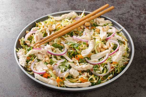 salade de poulet asiatique avec chou, oignons, carottes, herbes et arachides en gros plan dans une assiette. horizontal - culture vietnamienne photos et images de collection