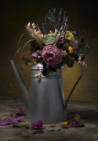 Dried flowers in a\nwatering can