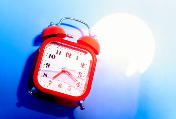 Yellow alarm clock on the wooden table.