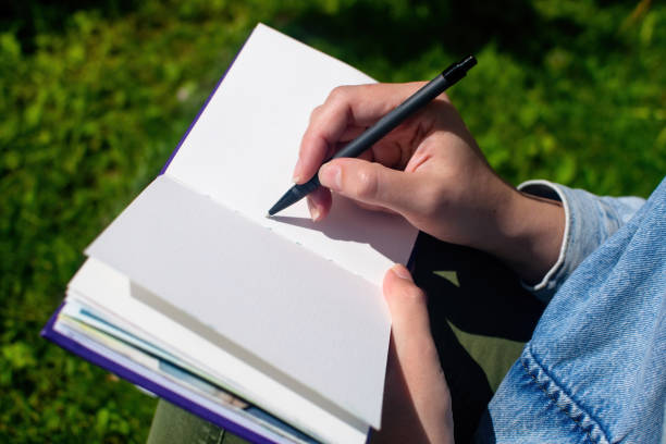 nahaufnahme der hände des mädchens, die in skizzenbuch und notizblock schreiben und zeichnen. ausbildung und studium, schulzeit. - nature writing women ideas stock-fotos und bilder