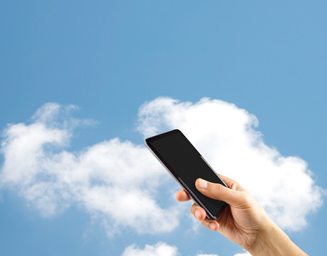 Male hand presenting a smartphone screen application over isolated cloud background.Online cloud communication concept