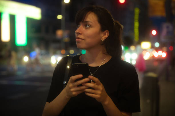 Woman using smartphone at night in the city
