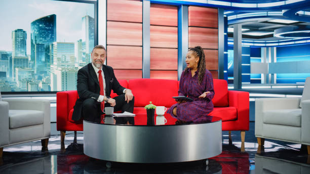 istock Talk Show TV Program and News Discussion: Two Charismatic Presenters Talk, Have Fun. Cable Channel Hosts Have Friendly Conversation. Morning, Breakfast Television Entertainment in Studio Concept 1407680212
