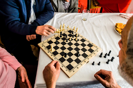 Playing chess with a small group of active seniors makes a social gathering fun.