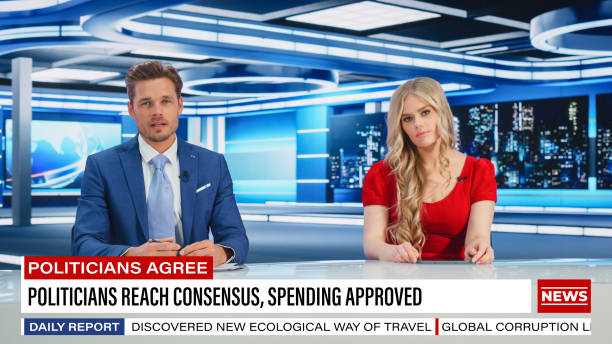 istock TV Live News Program: Two Presenters Reporting, Talking, Discuss Daily Events, Friendly Chat. Television Cable Channel Team of Male and Female Anchors Talk. Newsroom Studio Concept 1407680858