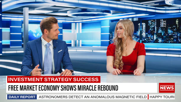 istock TV Live News Program: Two Presenters Reporting, Talking, Discuss Daily Events, Friendly Chat. Television Cable Channel Diverse Team of Male and Female Anchors Talk. Newsroom Studio Concept 1407681400