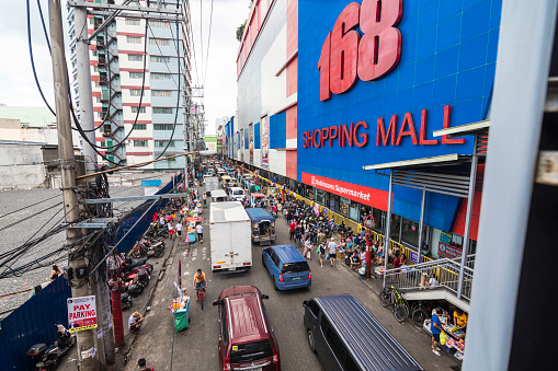 Divisoria, Manila, Philippines - Dec 2021: A busy scene along Soler Street, heavy one way traffic and a crowd of shoppers passing by 168 mall.