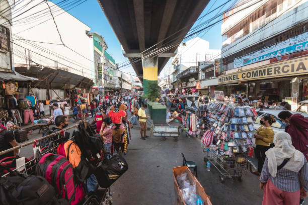 Paranaque, Metro Manila, Philippines - The bustling street market of Baclaran. The LRT line passes by overhead. Paranaque, Metro Manila, Philippines - Nov 2021: The bustling street market of Baclaran. The LRT line passes by overhead. divisoria market stock pictures, royalty-free photos & images
