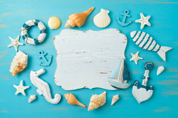 istock Flat lay summer beach composition with wooden board, sailing boat and nautical decorations over blue background. Top view 1407699287