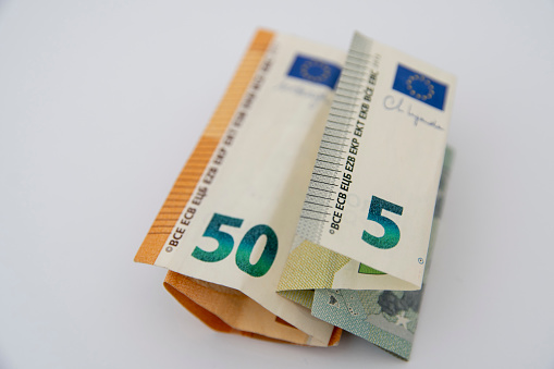 A close-up photo of euro bills lying on a white background