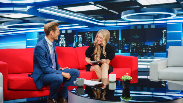istock Talk Show TV Program: Two Charismatic Presenters Talk. Cable Channel Hosts Have Conversation, Chat, Discuss News, Interview Guests, Have Fun. Mockup of Television Studio. Wide Shot 1407702486
