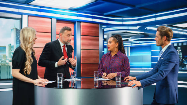 istock Talk Show TV Program: Four Diverse Specialists, Experts, Guests, Presenter, Host Discuss and Argue about Politics, Economy, Science, News. Mock-up Television Cable Channel Studio Debate 1407702577
