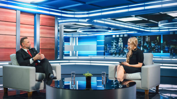 istock Talk Show TV Program Presenter and Celebrity Interview. Host and Guest Discuss Politics, Economy, Science, News, Entertainment. Mock-up of Cable Channel Studio. Wide Shot, Television Concept 1407702681