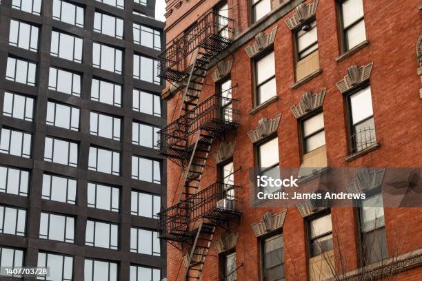 Old Brick Building With Fire Escapes Next To A Modern Residential Skyscraper In Tribeca Of New York City Stock Photo - Download Image Now