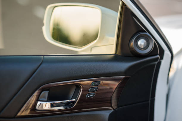 istock Car inside door chrome handle. Black leather and brown panel left door new car. Car interior. Panel with a memory of parameters of driver's seat. View from middle on the left front mirror from driver. 1407706311