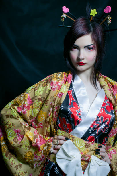 Beautiful young asian woman in kimono over dark background