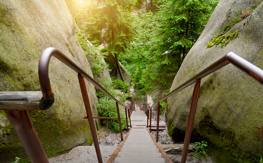 Steep narrow stairs with iron railing between the sandstone blocks in the rock garden Adersbach, Czech Republic