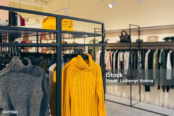 Fashion Store A Number Of Different Colorful Womens Clothes Hanging On A Shelf In The Show Room Stock Photo - Download Image Now