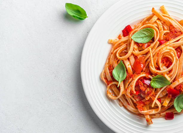 istock Linguini pasta with tomato sauce and basil on a gray background. 1407713334
