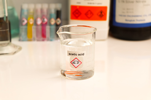 Acetic acid in glass, chemical in the laboratory and industry