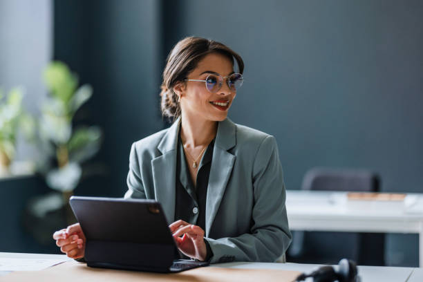 istock Smiling Business Woman Working On A Digital Tablet In The Modern Office 1407714082