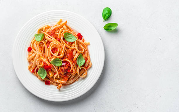 istock A portion of linguini pasta with tomato sauce and basil on a gray background with a copy space. 1407714938