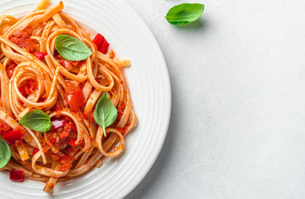 istock Pasta with tomato sauce and fresh basil on a gray background. 1407714955