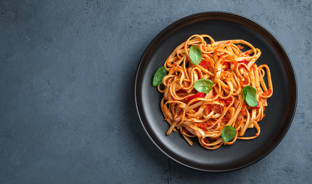 istock Linguini pasta with tomatoes and basil on a graphite background. Italian food. 1407716053