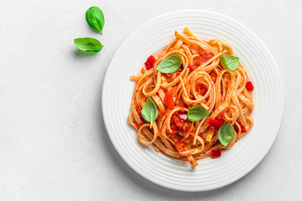 istock Linguini pasta with tomato sauce and basil on a gray background with a copy space. 1407716423