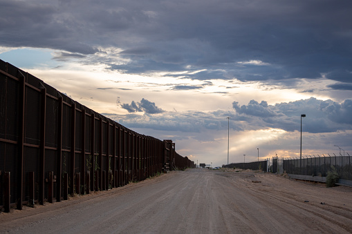 United States/Mexico Border Wall Between Sunland Park, New Mexico and Puerto Anapra Chihuahua Mexico Near the Santa Teresa Border Crossing Under a Dramatic Cloudscape Near Dusk