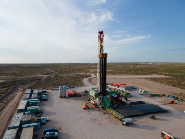 plataforma de perforación que crea un pozo de gas o petróleo silueteado al anochecer bajo un dramático cielo al atardecer - oil industry industry new mexico oil drill fotografías e imágenes de stock