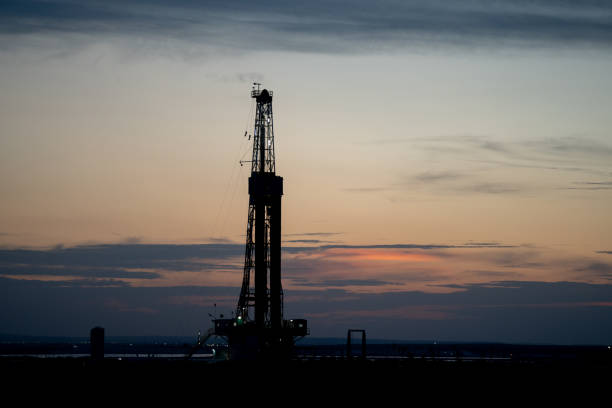 istock Fracking Drilling Rig Creating Gas or Oil Well Silhouetted at Dusk Under a Dramatic Sunset Sky 1407717335