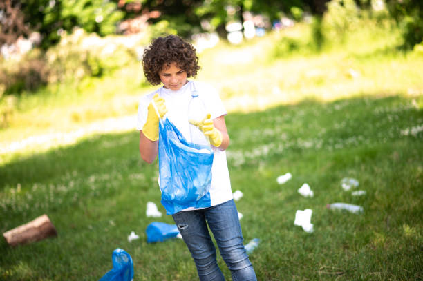 istock Curly-haired teen looking concentrated while gathering litter 1407717428