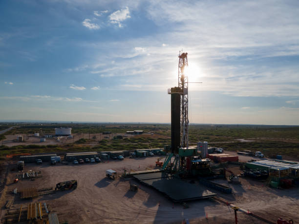 plataforma de perforación que crea un pozo de gas o petróleo silueteado al anochecer bajo un dramático cielo al atardecer - oil industry industry new mexico oil drill fotografías e imágenes de stock