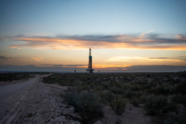 istock Fracking Drilling Rig Creating Gas or Oil Well Silhouetted at Dusk Under a Dramatic Sunset Sky 1407717470